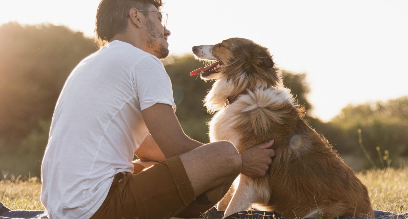 back-view-young-man-with-dog-seaside